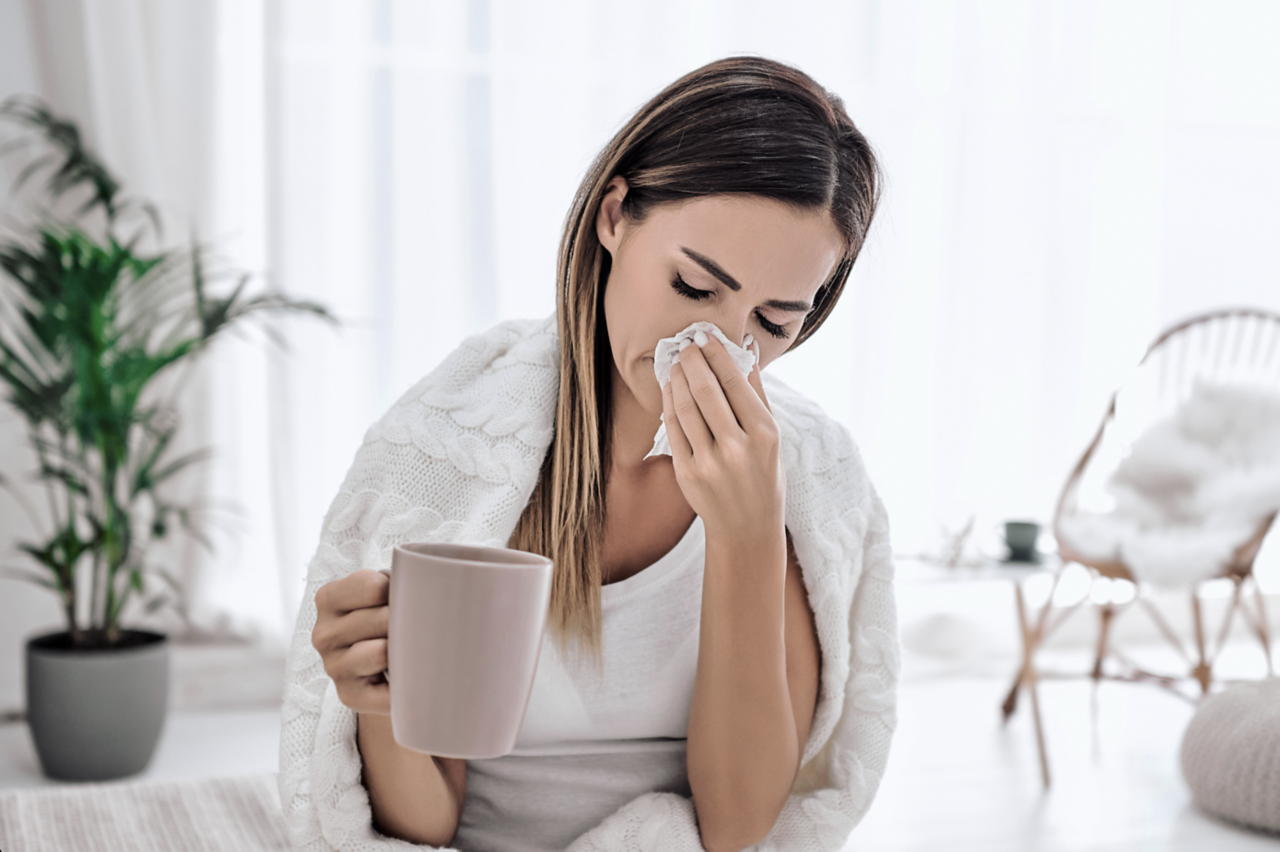 Woman sneezing with a cold